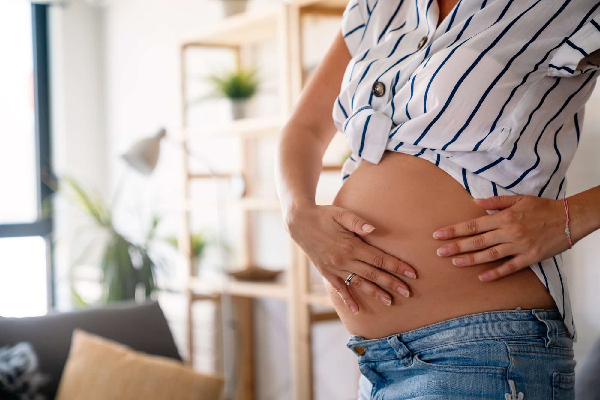 Care about perfect and smooth skin in pregnancy time. Pregnant woman using stretch mark cream