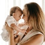 smiling woman carrying baby